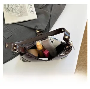 Vue intérieure montrant la capacité de stockage d'un sac à bandoulière marron à rivets