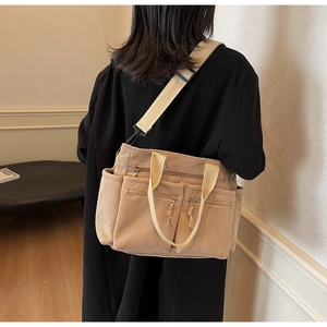 Vue détaillée du sac à bandoulière en velours côtelé kaki avec poches zippées et texture