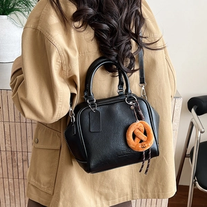 Nahaufnahme der schwarzen Bowling-Tasche mit orangefarbenem Anhänger und Kontrastnähten