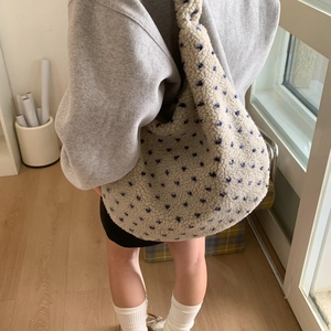 Detail of fuzzy cream lambskin tote bag with blue polka dots and soft hobo shoulder strap