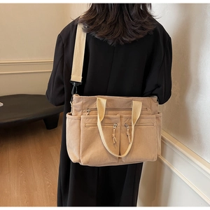 Détail du sac cabas en velours côtelé beige montrant la texture et les larges bandoulières