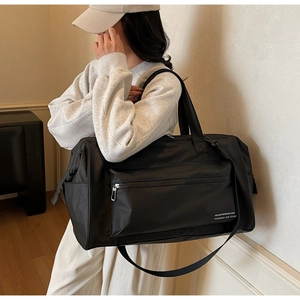 Sac de voyage noir imperméable avec bandoulière réglable dans un décor moderne chic