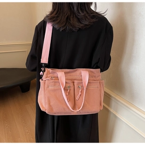 Gros plan détaillé du sac bandoulière en velours côtelé rose saumon multi-poches