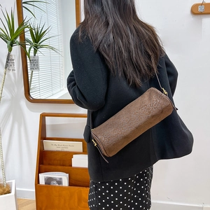 Detail of a cylinder shoulder bag with leopard print and elegant gold hardware