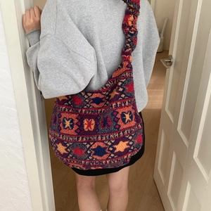 Detail of colorful geometric ethnic pattern on soft plush tote bag with ruched strap