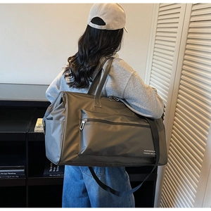 Vue de dos d'un mannequin portant le grand sac de voyage en nylon imperméable gris