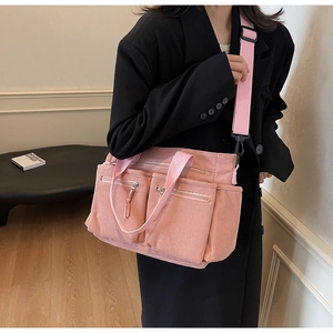 Détail du sac fourre-tout en velours côtelé rose avec doubles poches avant et bandoulière