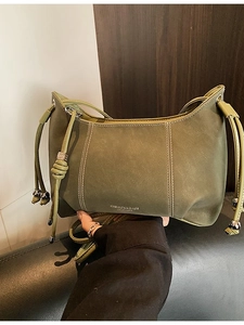 Minimalist olive green crossbody bag with white stitching and drawstring detail