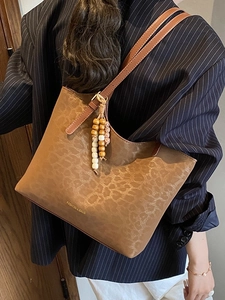 Brown leopard print faux leather tote bag with beaded charm on shoulder strap