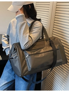 Sac de voyage imperméable vert olive foncé avec bandoulière porté par un mannequin homme