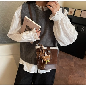 Bolso tipo cubo marrón con ribete de piel blanca y colgante de oso estilo vintage