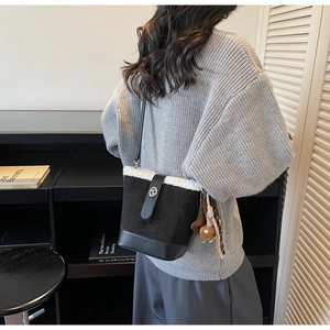 Detalle del bolso cubo de invierno con ribete de piel blanca y cierre giratorio plata