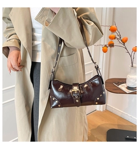 Détail du sac sous le bras marron brillant avec boucle en métal et rivets dorés