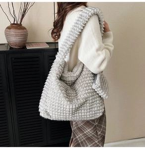 Close-up of grey ruched cloud tote bag with plush texture and matching small coin purse