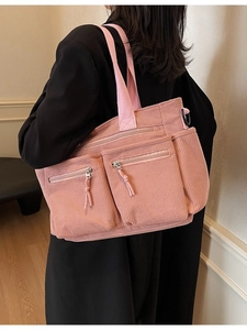 Sac fourre-tout en velours côtelé rose avec poches multiples porté par un mannequin