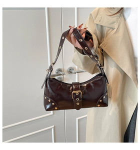 Détail du sac porté épaule en cuir marron foncé avec rivets dorés et boucles Y2K