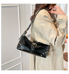 Détail du sac d'épaule punk noir avec rivets dorés et finition en cuir ciré brillant