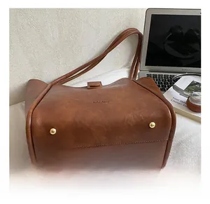 Close-up of golden hardware studs on a brown vintage leather tote bag bottom