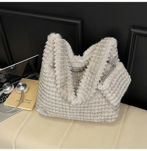 Detail of grey faux fur tote bag with wavy texture and matching small zipper pouch