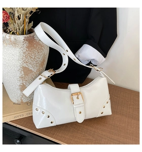 Détail du sac à bandoulière punk blanc brillant avec boucles dorées et rivets en métal