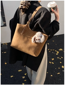 Brown suede tote bag with plush rabbit charm in an autumn street style scene