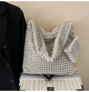 Detail of light gray faux fur tote with horizontal striped texture and matching mini pouch
