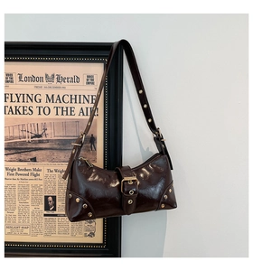 Détail du sac baguette punk marron vintage avec rivets dorés et œillets en métal