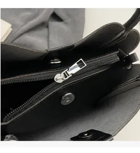 Détail de la fermeture éclair argentée et du fermoir magnétique du sac seau en cuir noir