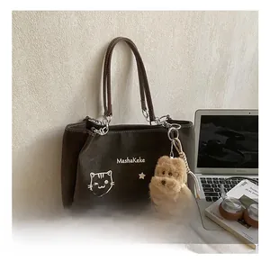 Dettaglio borsa tote marrone scuro con logo MashaKeke, grafica gatto e ciondolo a cane