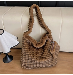 Detailed view of brown plush tote bag with checkerboard texture and side zipper pouch