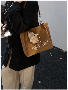 Borsa tote in camoscio marrone con stampa gatto e ciondolo orso indossata