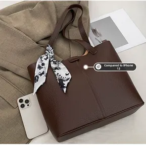 Deep brown pebble leather tote bag showing size comparison with an iPhone 12