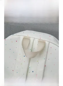 Detail view of durable woven top handle and stitching on the white floral canvas backpack