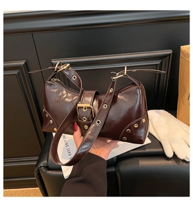 Détail du sac d'épaule en cuir verni marron foncé avec rivets dorés et boucle oversize