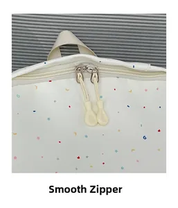 Detail of smooth dual zippers and colorful star patterns on white leather backpack