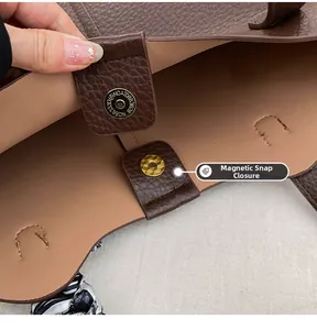 Detail of dark brown leather tote bag showing the magnetic buckle closure and silk scarf