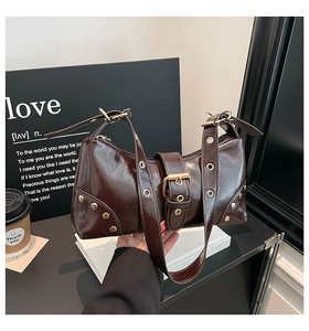 Gros plan du sac porté épaule marron vintage avec œillets et grande boucle décorative