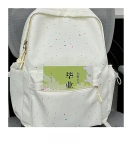 Detailed view of the white student backpack featuring colorful moon and star patterns
