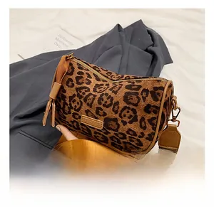 Close-up of leopard print Boston bag with wide nylon strap and gold metal hardware
