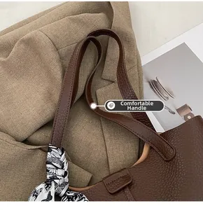 Detail of dark brown lychee leather tote with a decorative silk butterfly scarf on the handle