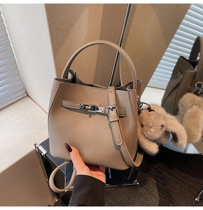 Dettaglio della borsa a secchiello taupe in pelle martellata con chiusura girevole