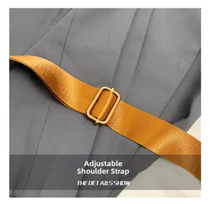 Detail of adjustable orange textile shoulder strap with golden metal buckle on Boston bag