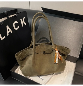 Detail of forest green suede tote bag with beaded tassel in a premium gift box