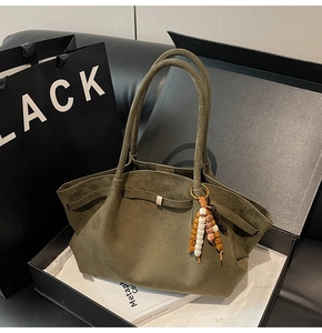 Detail of dark green suede tote bag with stylish beaded tassel and metal buckle inside
