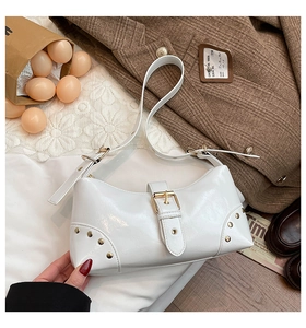 Gros plan sur le sac épaule en cuir verni blanc avec rivets et boucle tendance
