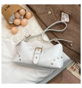 Détail du sac à bandoulière punk blanc brillant avec rivets dorés et boucle métallique