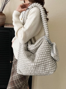 Retro grey plush shoulder bucket bag with matching pouch on model in minimal interior