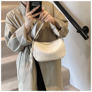 Creamy white crescent shoulder bag featuring wide geometric jacquard strap in casual style