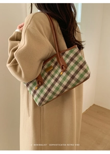 Détail du sac cabas à carreaux avec lanières en cuir marron et plaque logo dorée