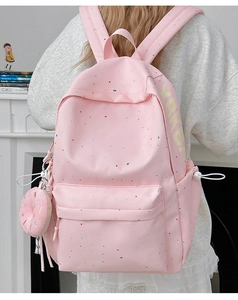 Pink polka dot backpack with adjustable wide shoulder straps and donut plush charm